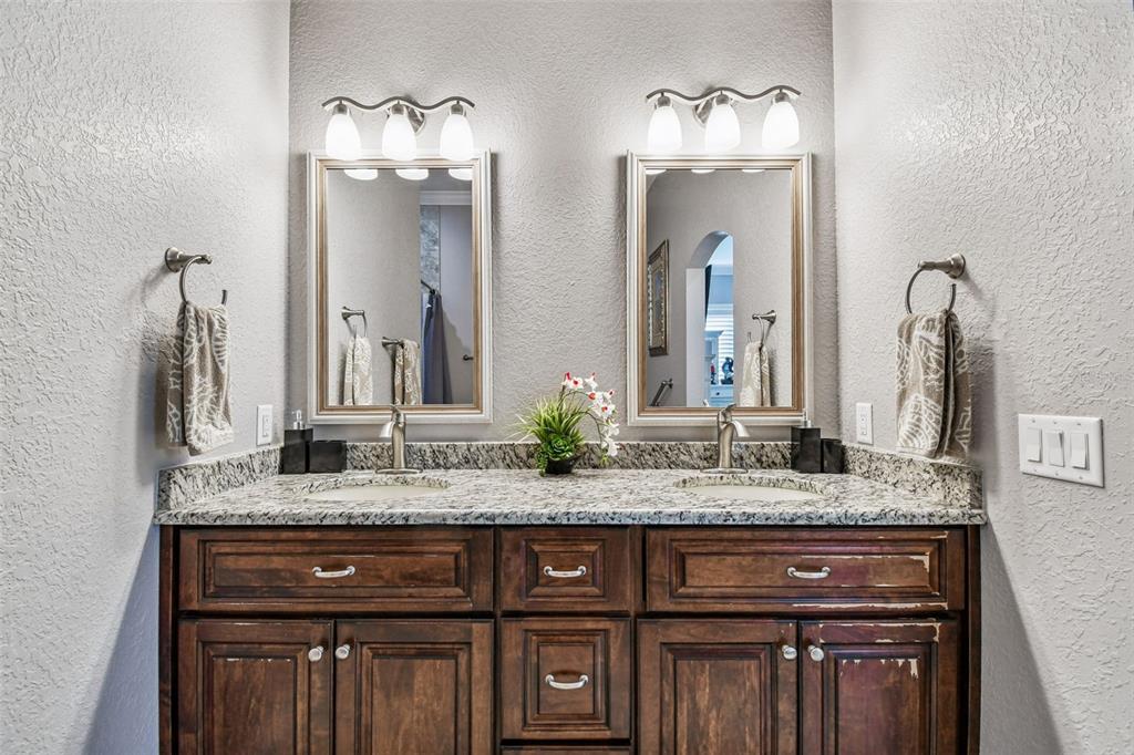582 Johns Pass Avenue Madeira Beach, FL 33708 - Photo 59 of 100 a bathroom with a granite countertop double vanity sink and two mirror