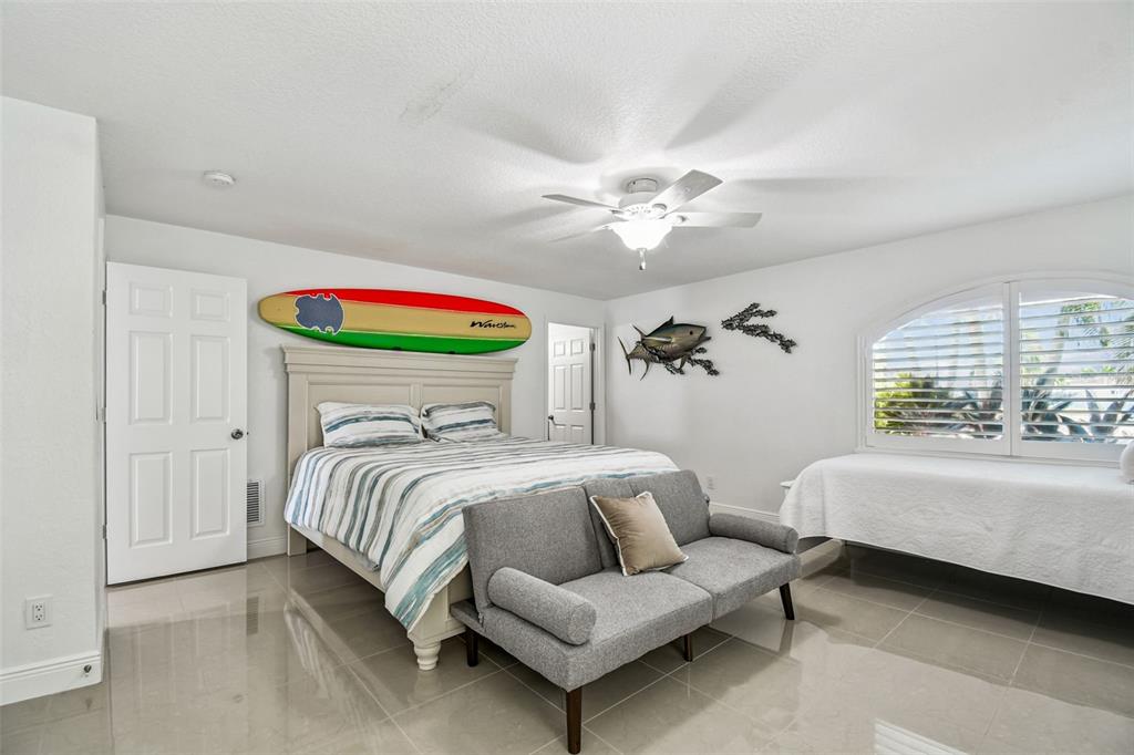 582 Johns Pass Avenue Madeira Beach, FL 33708 - Photo 61 of 100 a bedroom with a bed and a chandelier