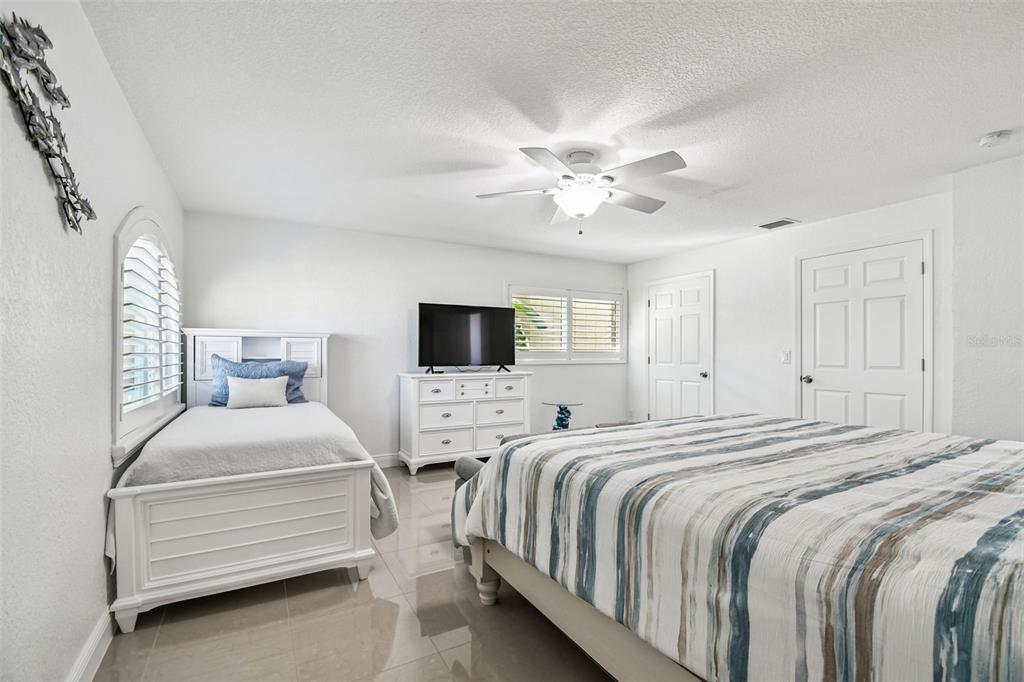582 Johns Pass Avenue Madeira Beach, FL 33708 - Photo 63 of 100 a bedroom with a bed and a chandelier