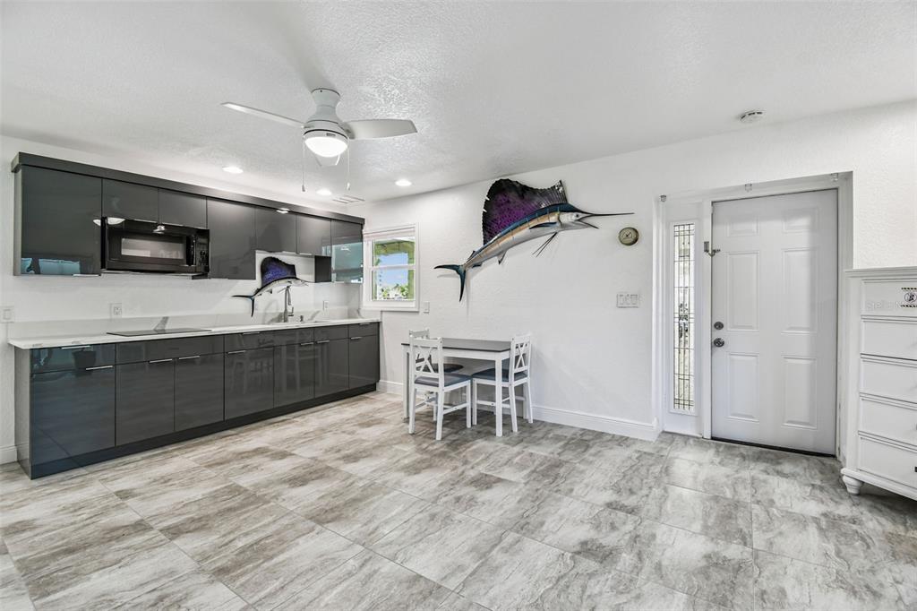 582 Johns Pass Avenue Madeira Beach, FL 33708 - Photo 80 of 100 a large white kitchen with a sink and dishwasher a stove top oven with wooden floor
