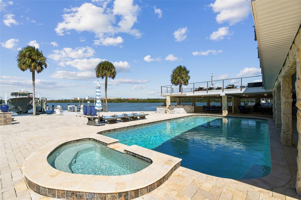 582 Johns Pass Avenue Madeira Beach, FL 33708 - Photo 86 of 100 a view of a swimming pool with a lounge chairs