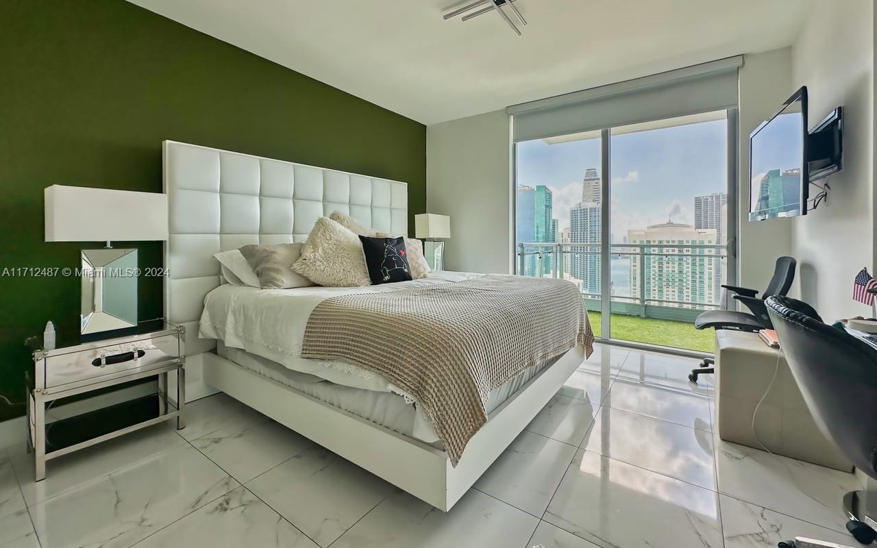 92 Southwest 3rd Street, Unit 4411 Miami, FL 33130 - Photo 2 of 17 a bedroom with a bed a lamp and a large window