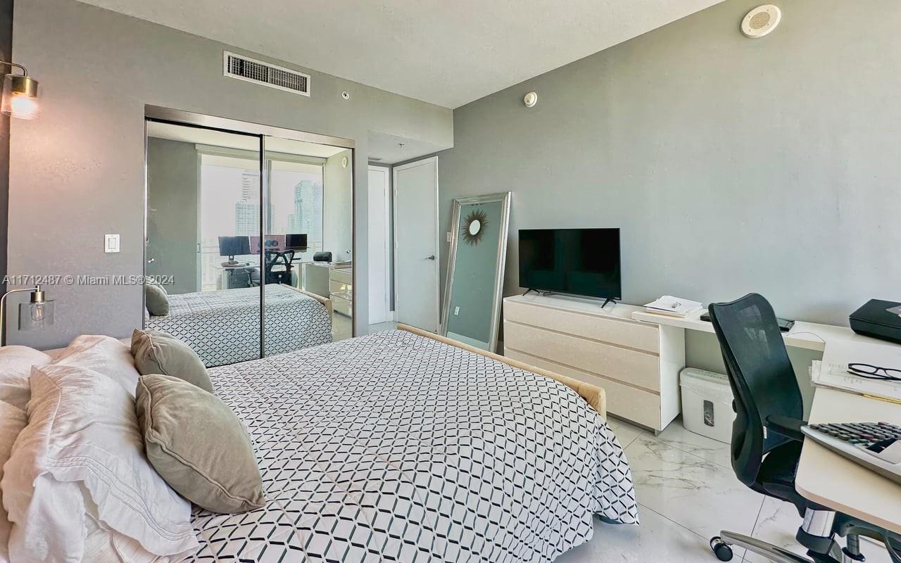 92 Southwest 3rd Street, Unit 4411 Miami, FL 33130 - Photo 7 of 17 a bedroom with a bed and a flat screen tv