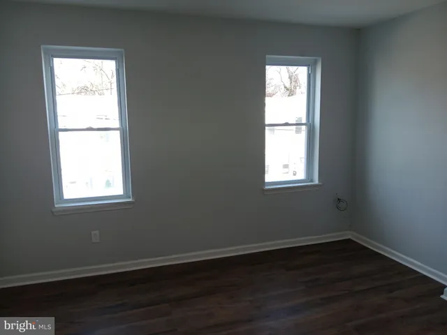 an empty room with wooden floor and a window