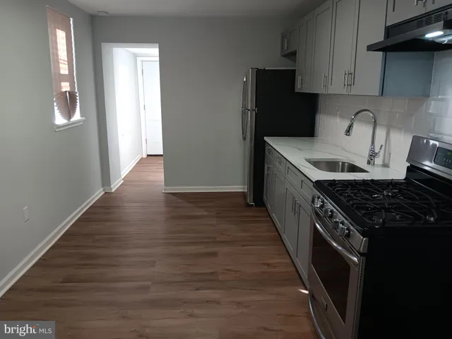 a kitchen with granite countertop a stove and a wooden floor