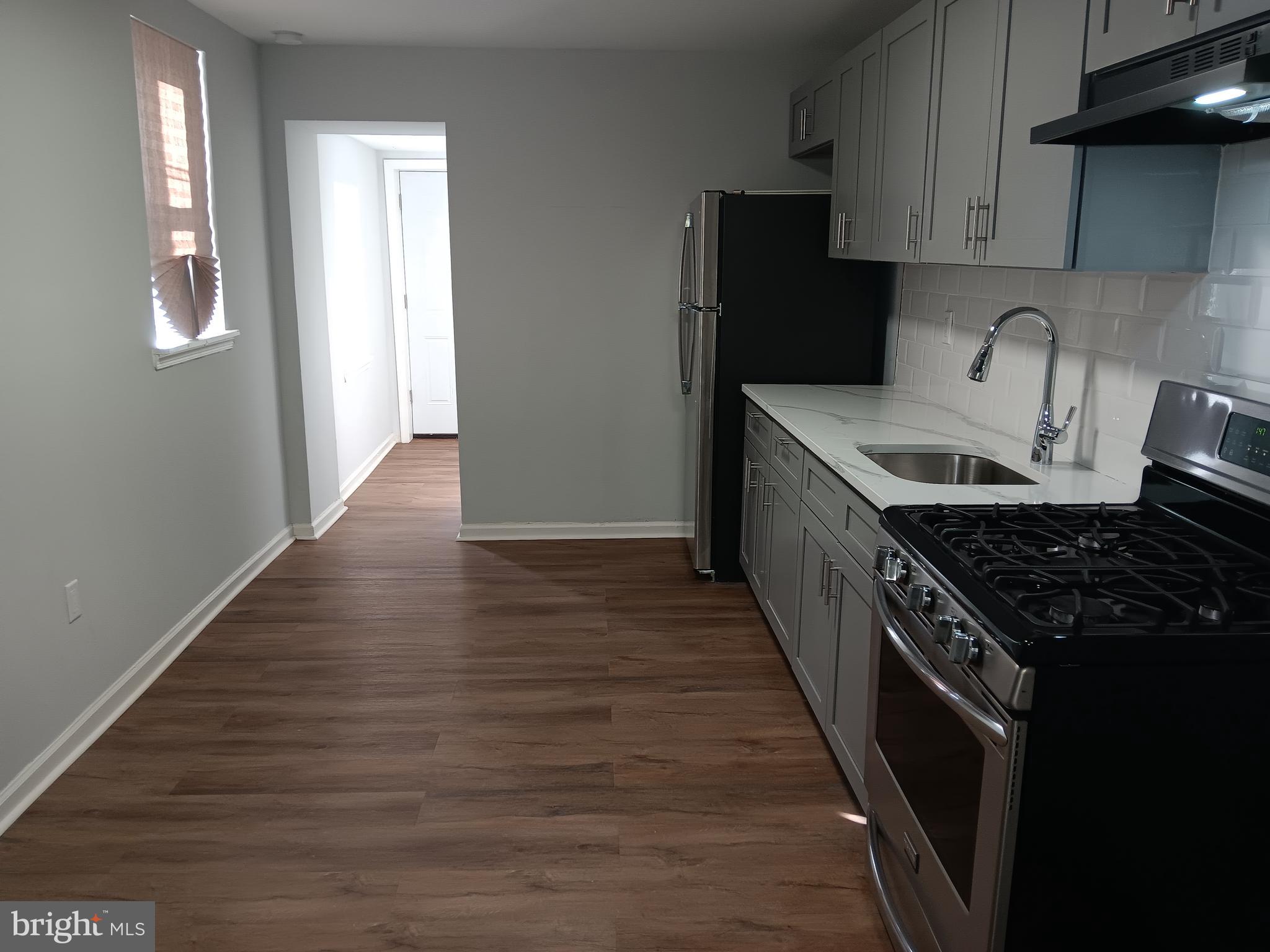 1012 Potter Street Chester, PA 19013 - Photo 2 of 19 a kitchen with granite countertop a stove and a wooden floor