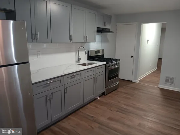 a kitchen with stainless steel appliances granite countertop a refrigerator sink and stove