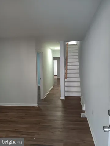 a view of a room with wooden floors and stairs