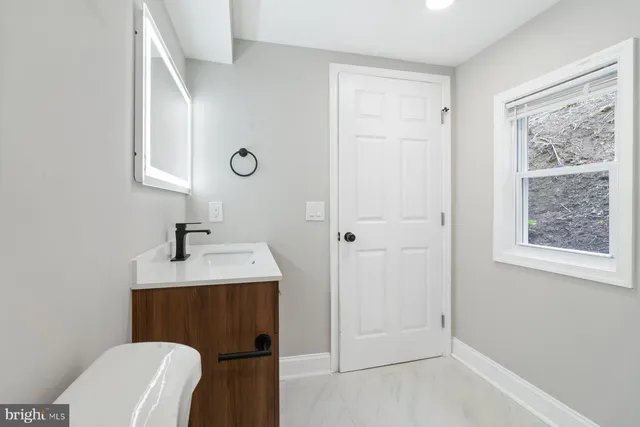a bathroom with a toilet a sink a vanity and mirror