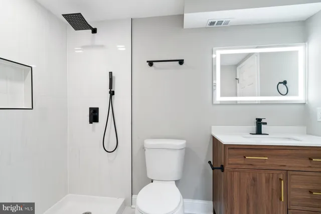 a bathroom with a toilet sink shower and mirror