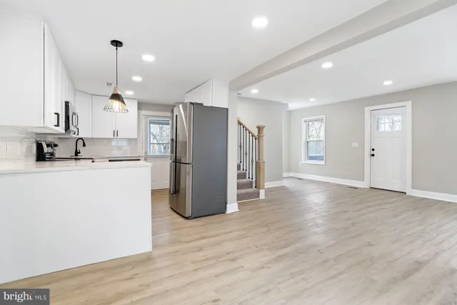 a kitchen with stainless steel appliances granite countertop a refrigerator a sink and a stove