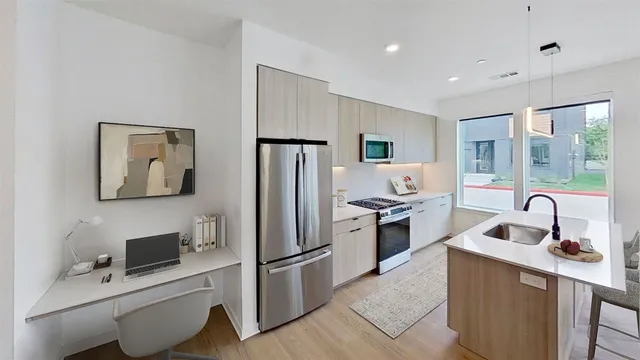 a kitchen with stainless steel appliances a refrigerator sink and stove