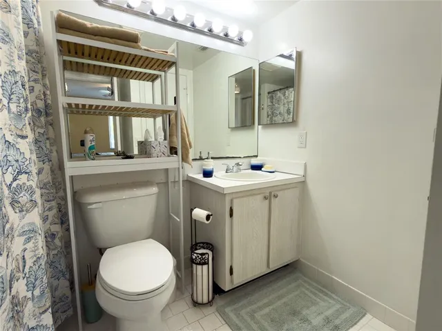 a bathroom with a sink toilet and mirror