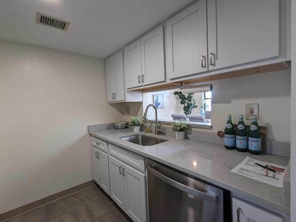 750 Davol Street, Unit 1214 Fall River, MA 02720 - Photo 8 of 42 a kitchen with a sink and cabinets