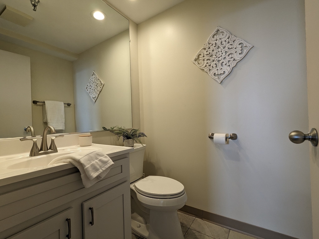 750 Davol Street, Unit 1214 Fall River, MA 02720 - Photo 9 of 42 a bathroom with a toilet sink and mirror