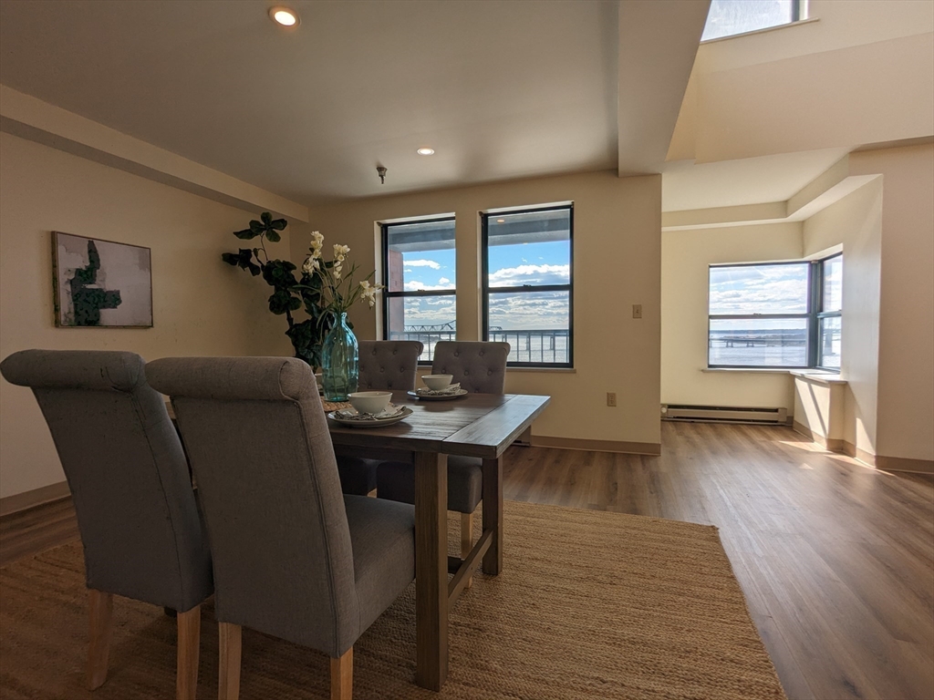 750 Davol Street, Unit 1214 Fall River, MA 02720 - Photo 10 of 42 a living room with furniture a dining table and wooden floor