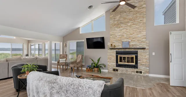 a living room with furniture a flat screen tv and a fireplace