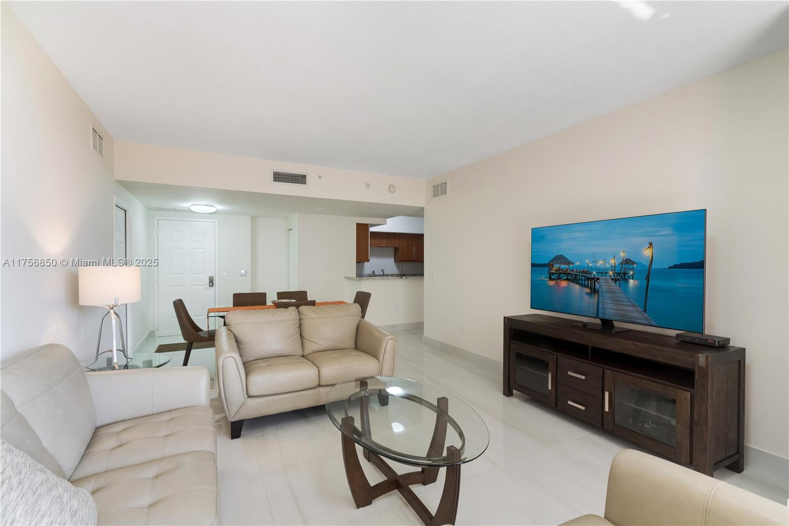888 Douglas Road, Unit 404 Coral Gables, FL 33134 - Photo 3 of 21 a living room with furniture a lamp and a flat screen tv