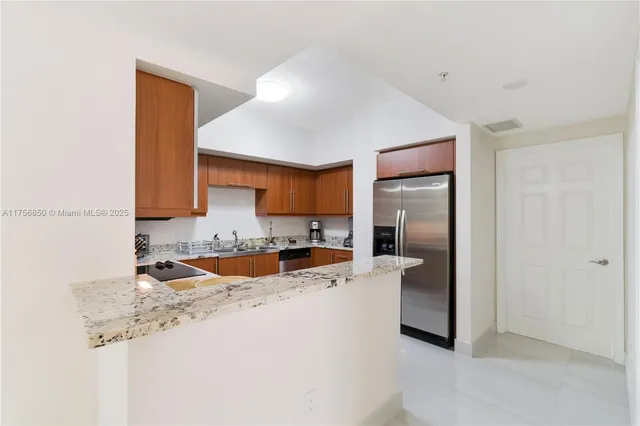 a kitchen with stainless steel appliances granite countertop a sink stove and refrigerator