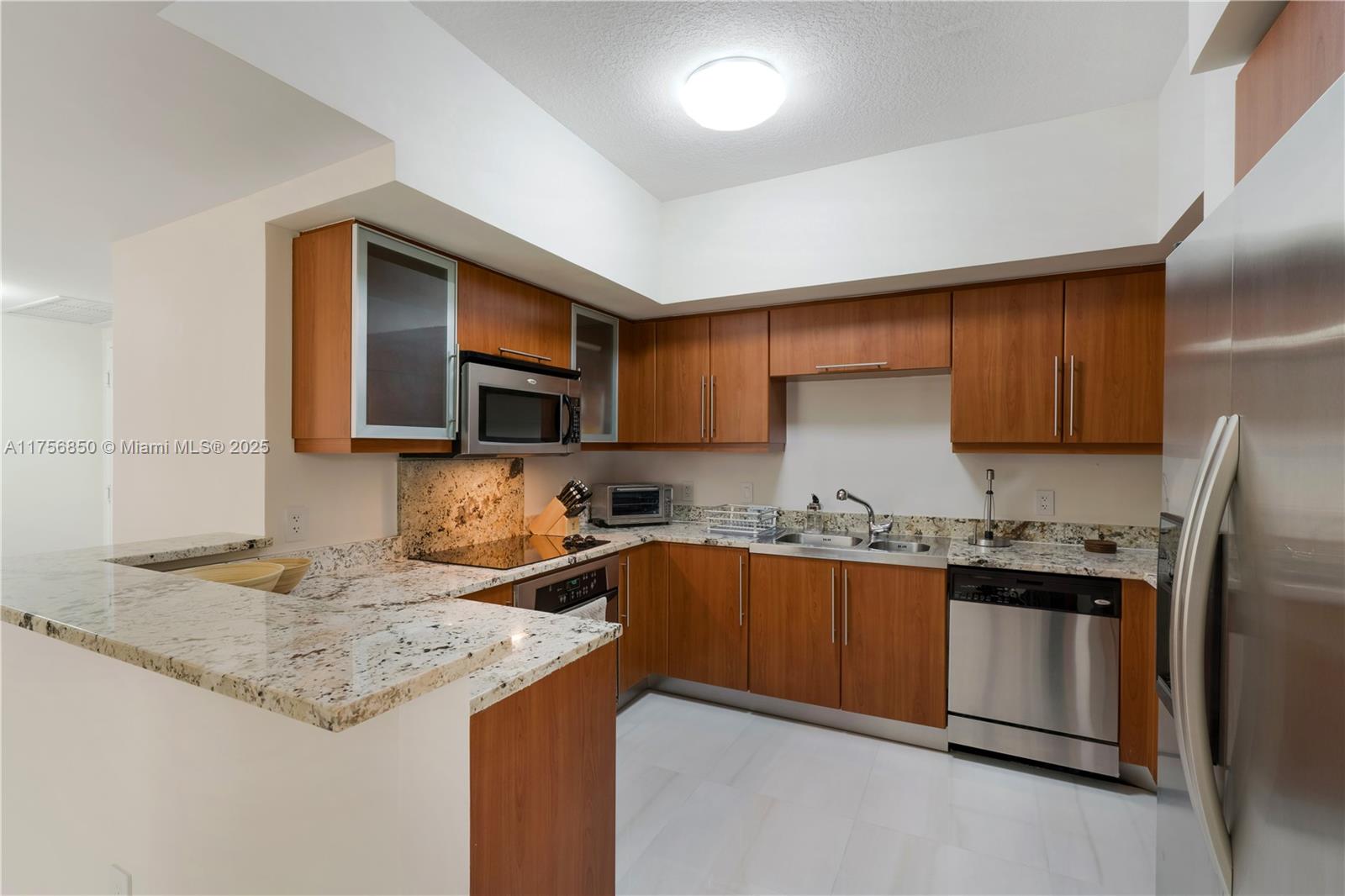888 Douglas Road, Unit 404 Coral Gables, FL 33134 - Photo 6 of 21 a kitchen with stainless steel appliances granite countertop a sink stove and refrigerator