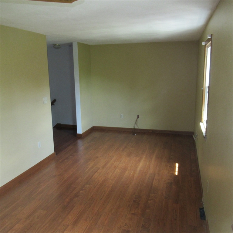 52 Apache Way, Unit 52 Tewksbury, MA 01876 - Photo 13 of 19 an empty room with wooden floor and windows