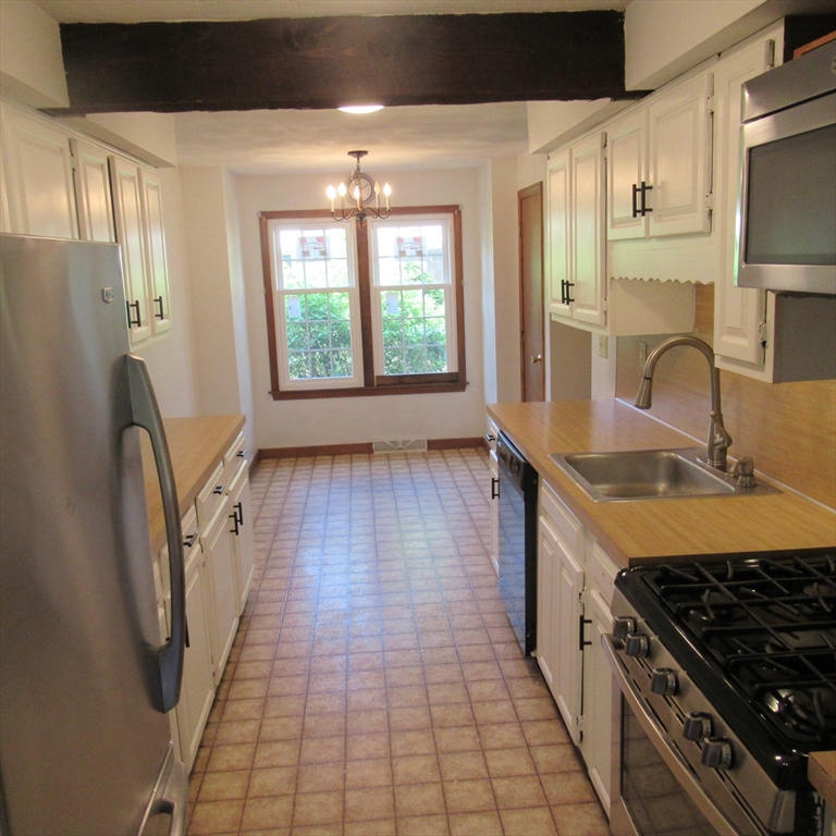 52 Apache Way, Unit 52 Tewksbury, MA 01876 - Photo 6 of 19 a kitchen with granite countertop a sink a counter space and stainless steel appliances