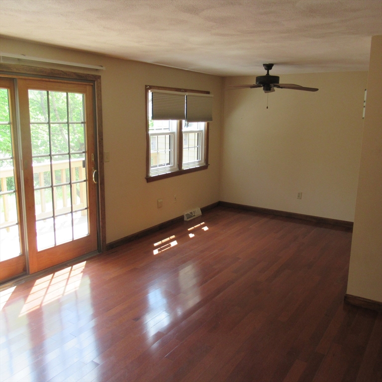 52 Apache Way, Unit 52 Tewksbury, MA 01876 - Photo 10 of 19 a view of an empty room with a window and wooden floor