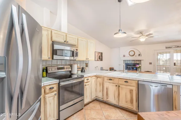 a kitchen with stainless steel appliances granite countertop a sink a stove and a refrigerator