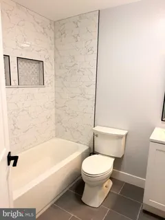 a white toilet sitting next to a bath tub