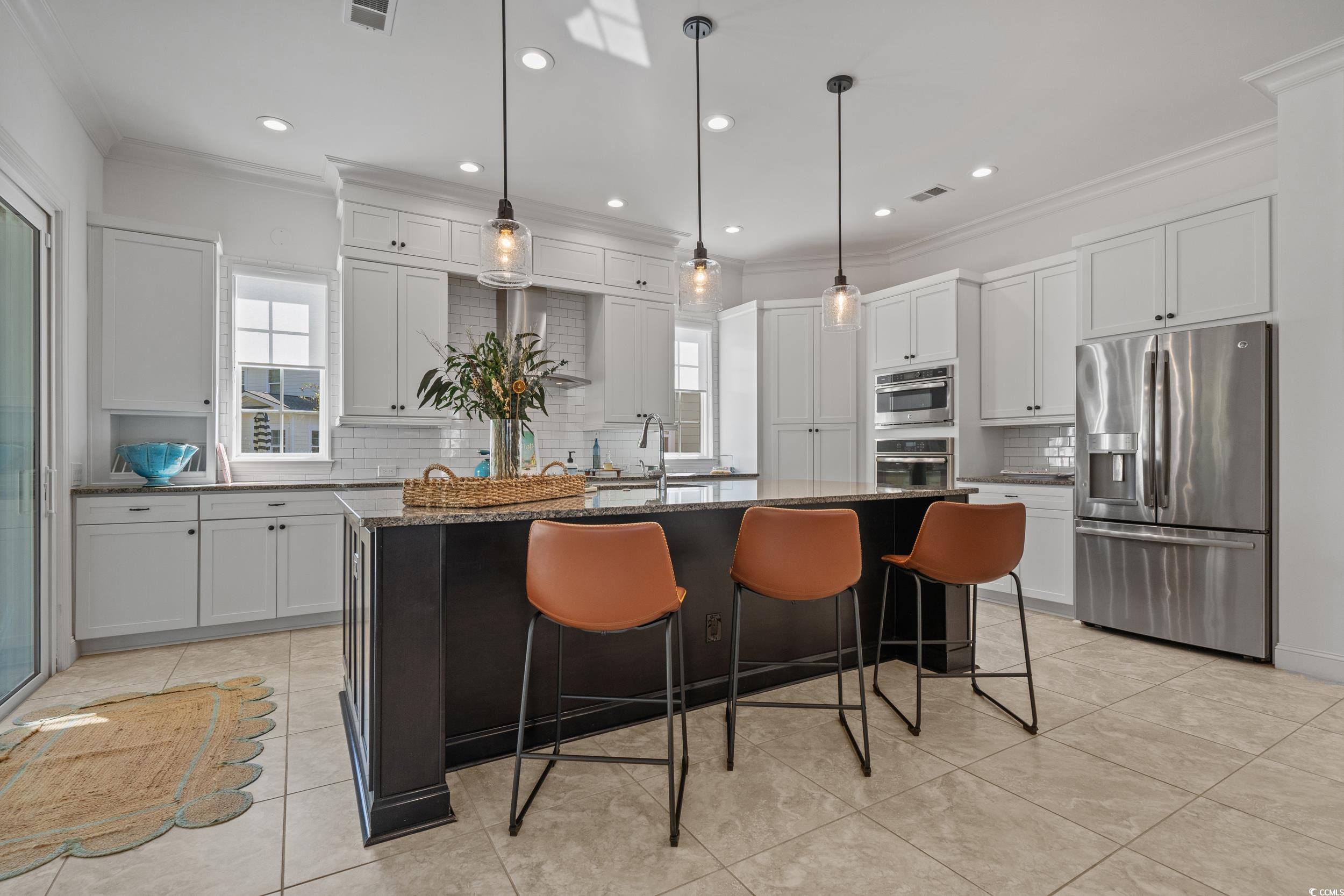 496 Starlit Way Myrtle Beach, SC 29579 - Photo 14 of 40 Kitchen featuring ornamental molding, tasteful backsplash, stainless steel appliances, dark stone countertops, and pendant lighting