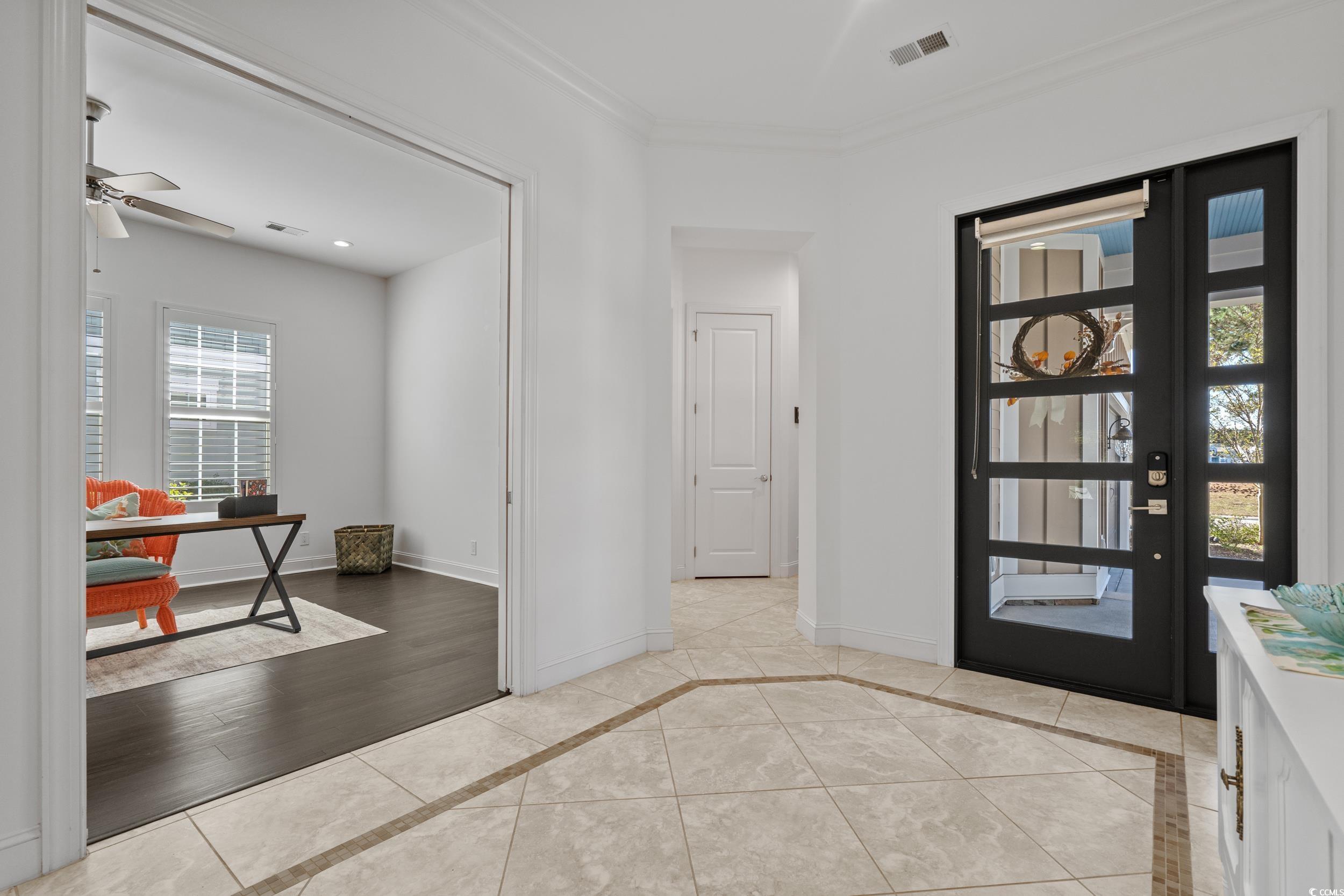 496 Starlit Way Myrtle Beach, SC 29579 - Photo 9 of 40 Foyer entrance featuring inlaid floor details, ornamental molding, ceiling fan, and light tile patterned floors