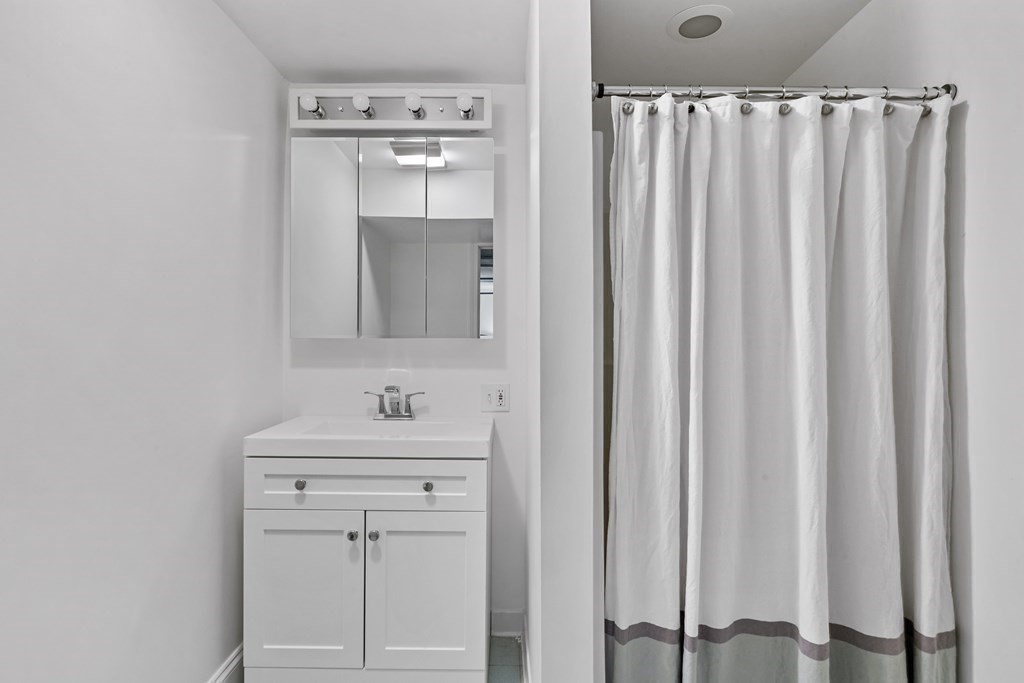 72 Salisbury Road Brookline, MA 02445 - Photo 31 of 40 a bathroom with a sink a mirror and a vanity
