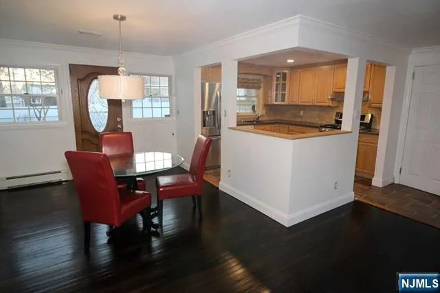 a living room with a dining table wooden floor and a fireplace