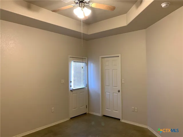 an empty room with a chandelier fan