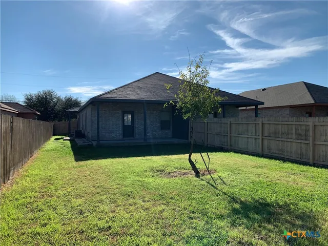 a view of a backyard with a garden and entertaining space