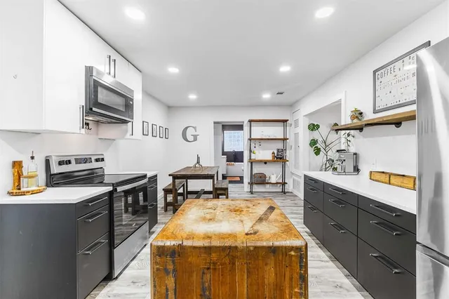 a kitchen with stainless steel appliances granite countertop sink stove top oven and cabinets