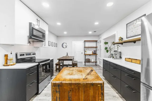 a kitchen with stainless steel appliances granite countertop sink stove top oven and cabinets
