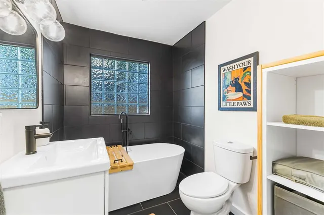 a bathroom with a toilet a sink and a window