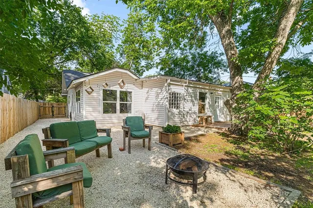 a view of house with backyard and sitting area