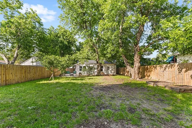 a view of a yard with a house and large trees