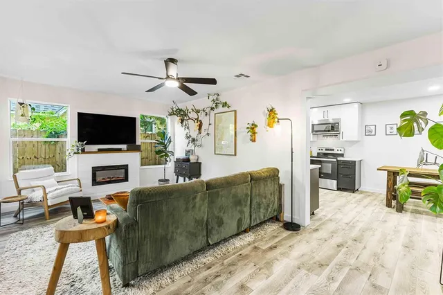 a living room with furniture a flat screen tv and a fireplace