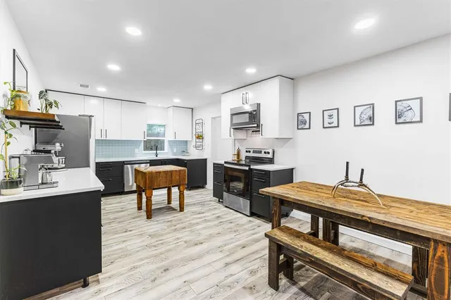 a kitchen with a table chairs microwave and cabinets