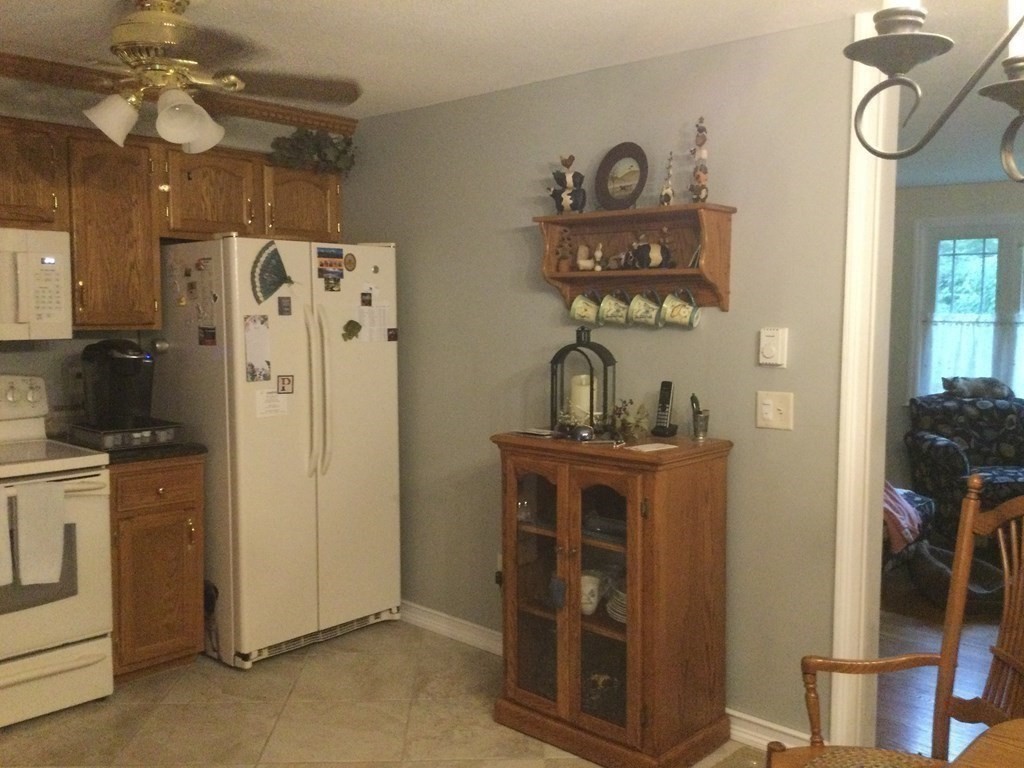 30 Meadow Road Ware, MA 01082 - Photo 13 of 26 a kitchen with stainless steel appliances granite countertop a refrigerator a stove and a dining table with wooden floor