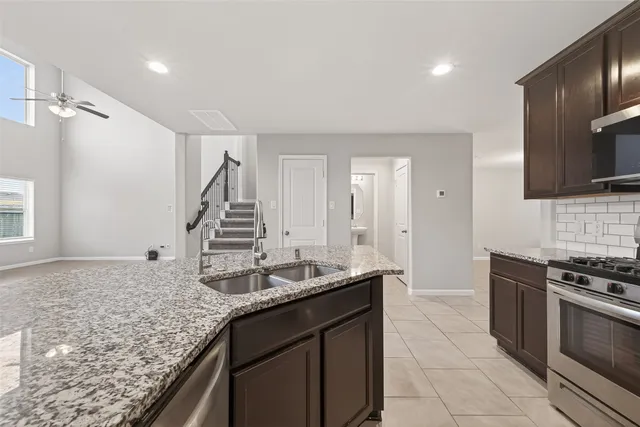 a kitchen with stainless steel appliances granite countertop a sink stove and refrigerator