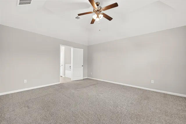 an empty room with windows and ceiling fan