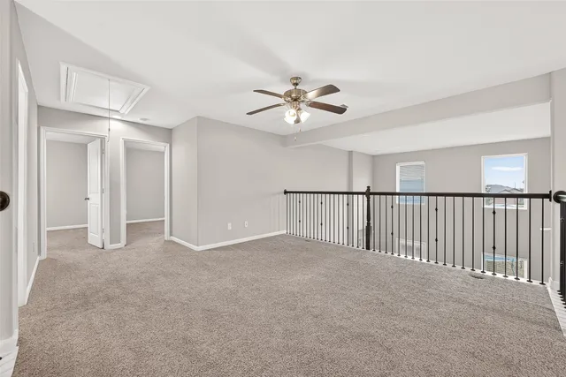 a view of an empty room and chandelier fan