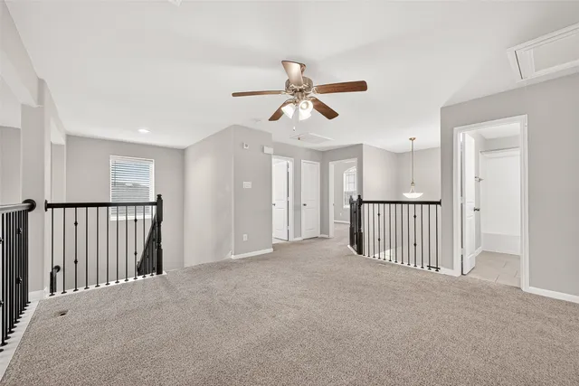a view of a hallway with a chandelier fan