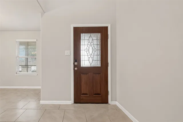 an entryway view with wooden floor and cabinet