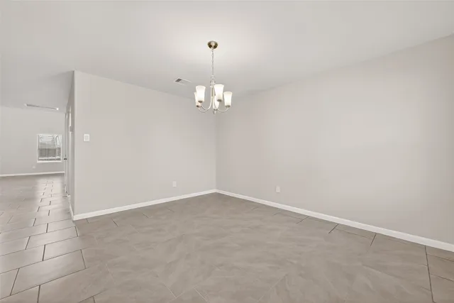 an empty room with chandelier and windows