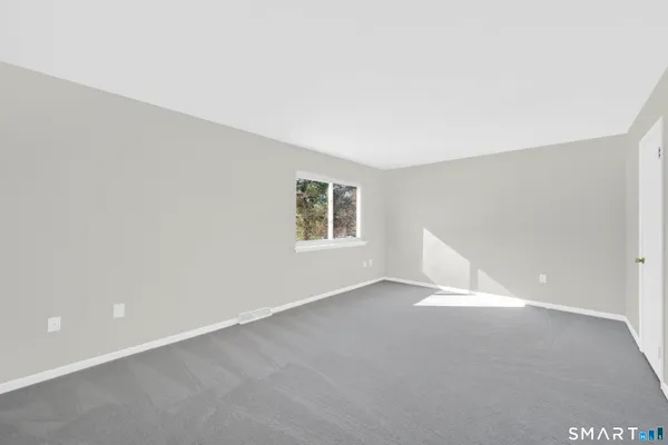 a view of an empty room with wooden floor and a cabinet